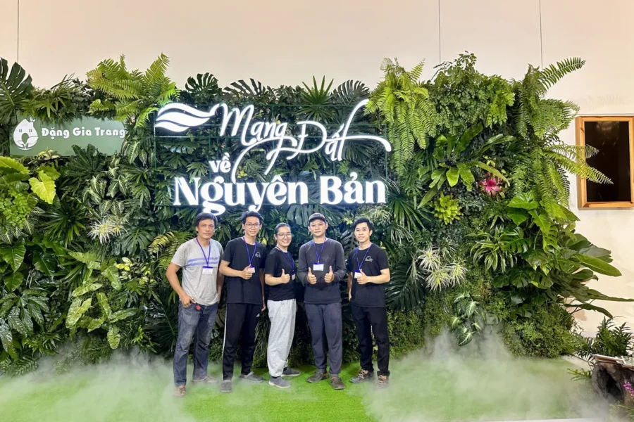 backdrop cây thật sự kiện Đặng Gia Trang với chữ nổi phát sáng