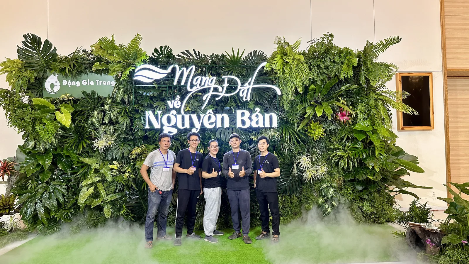 backdrop cây thật sự kiện Đặng Gia Trang với chữ nổi phát sáng