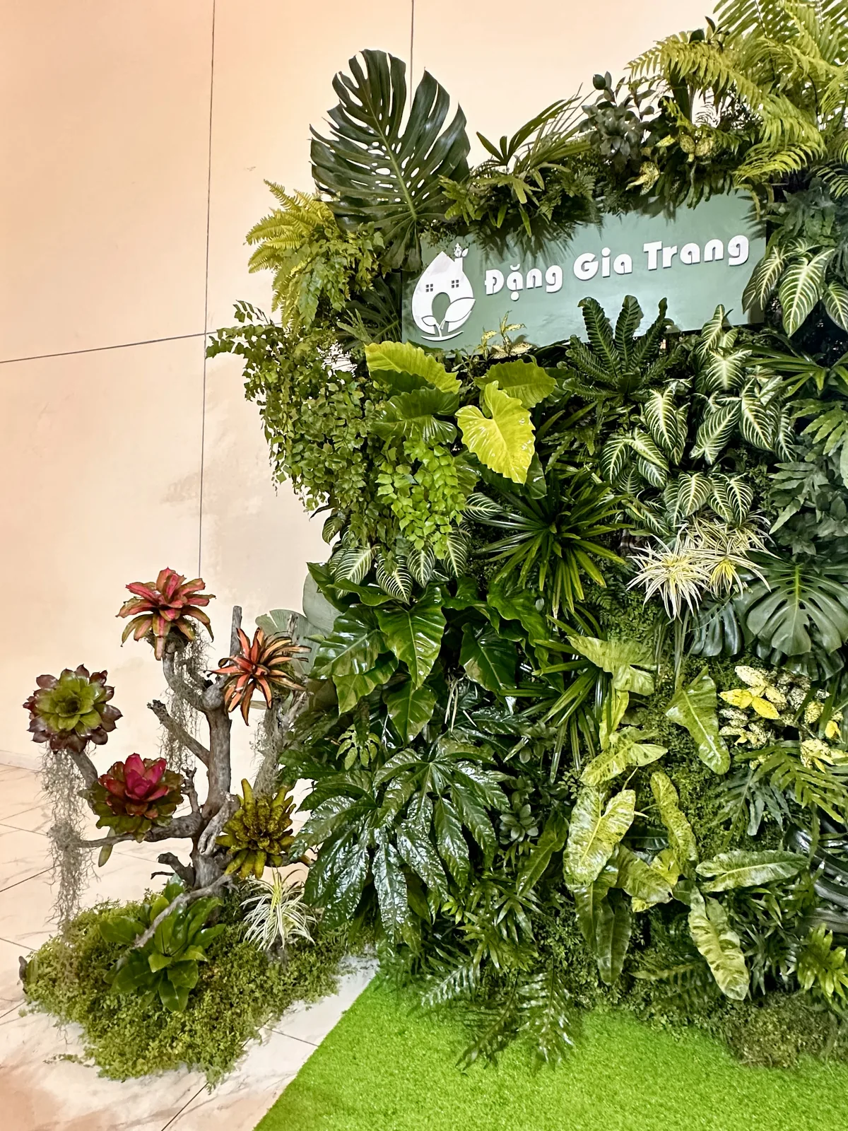 Vertical view of the Dang Gia Trang logo over the live green wall